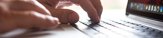 Hands typing on a laptop